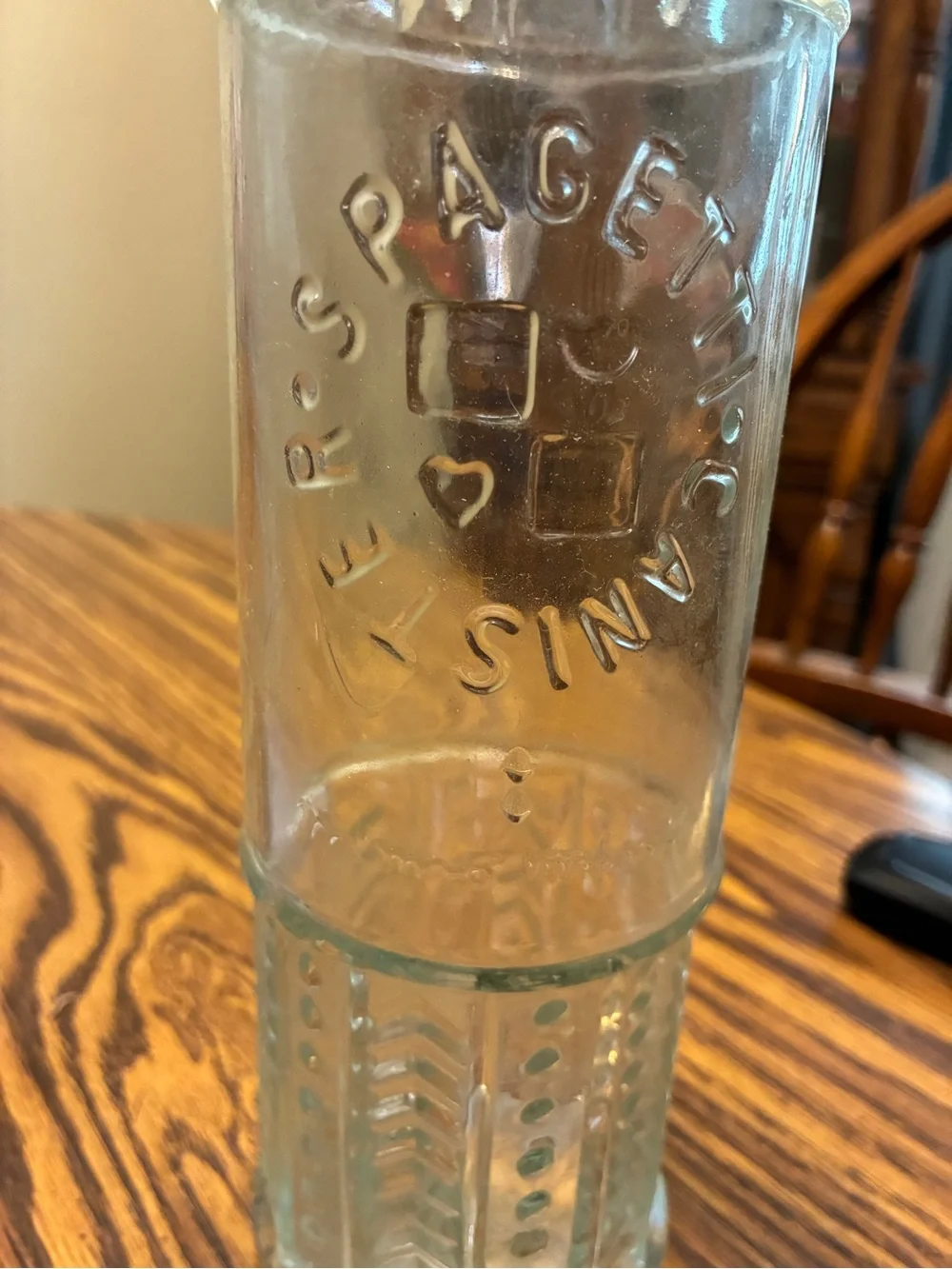 vintage glass spaghetti canister features an embossed circular logo